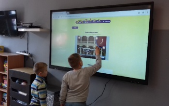 Powiększ obraz: uczniowie korzystają z tablicy interaktywnej na świetlicy szkolnej